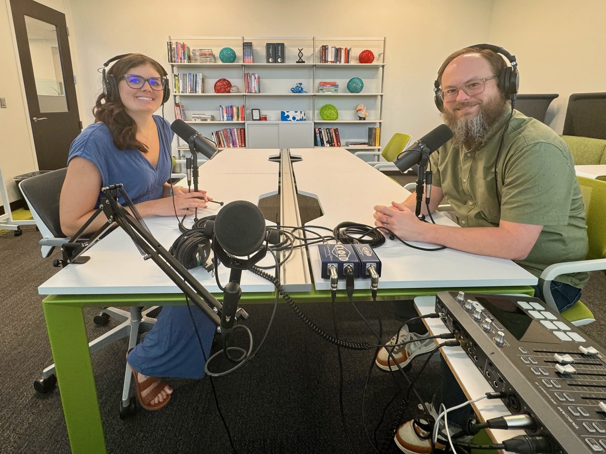 A woman and a man podcasting in a studio 