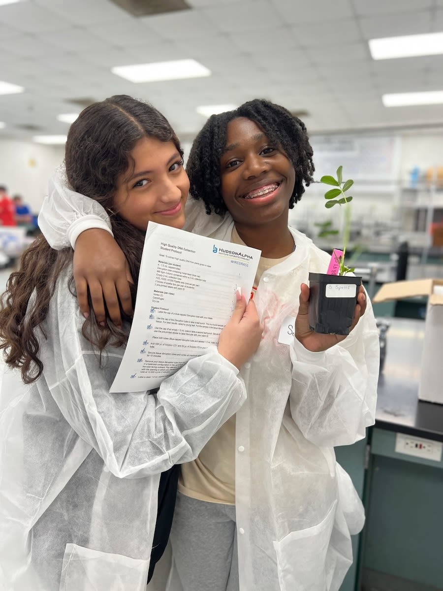 Two young students with a peanut plant 