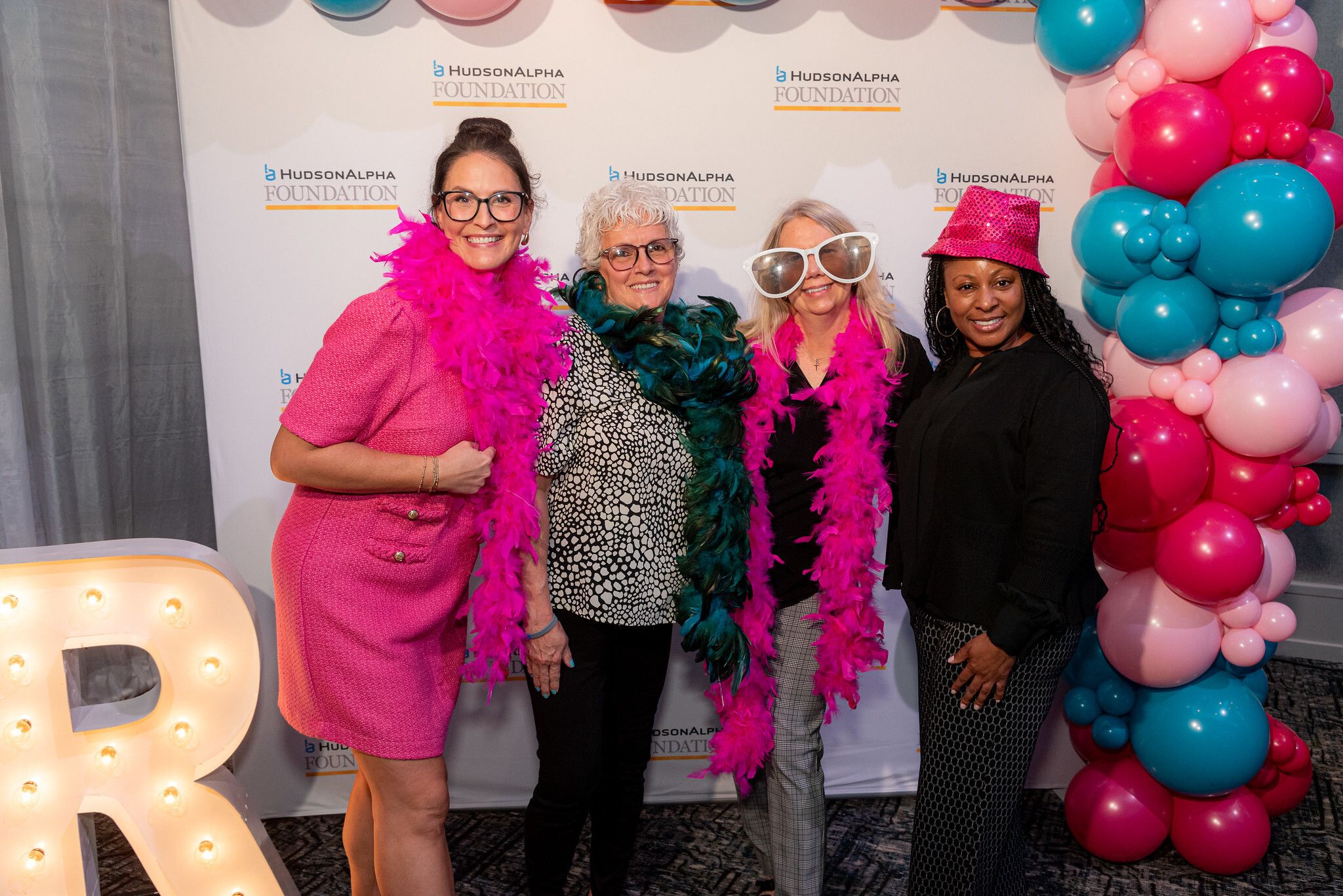 Four women taking a photo at a photo booth