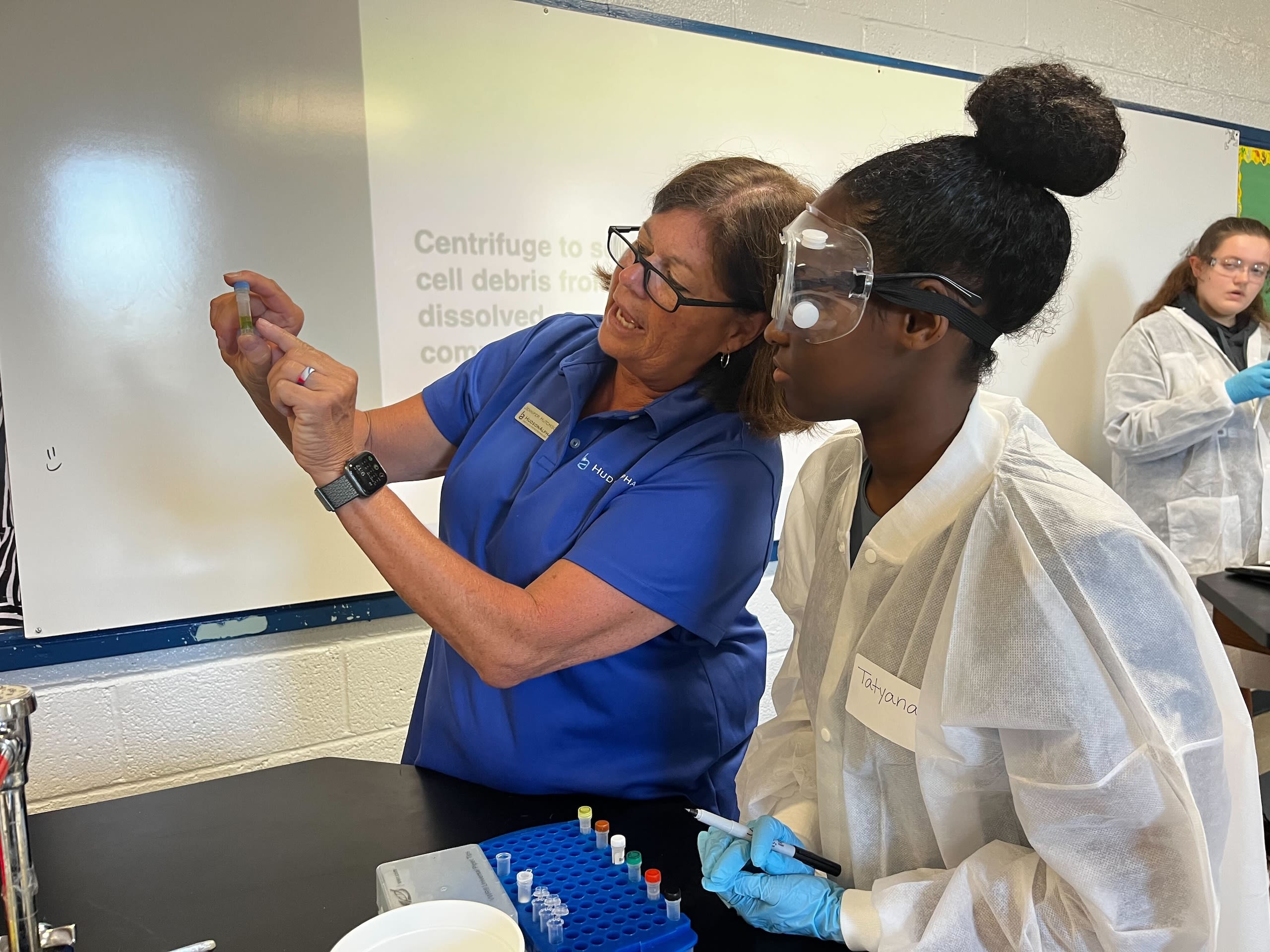 A teacher showing a student a tube of DNA